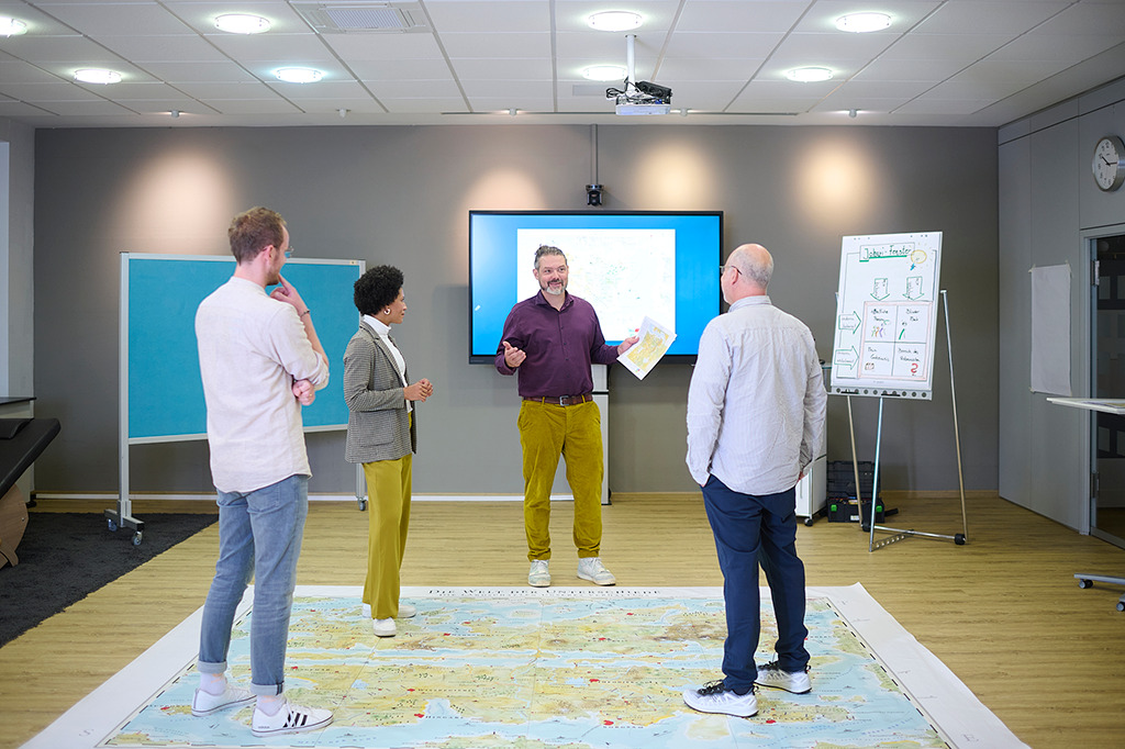 "Ein Team steht auf der Bodenkarte des menschlichen Verhaltens in einem MapsTell
Workshop"